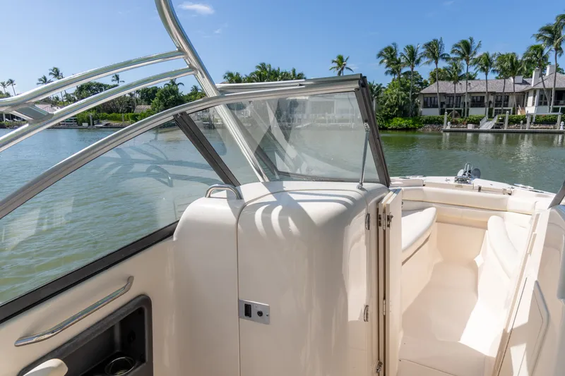 Slide: The Image of 2018 Grady-White Freedom 255 boat interior with waterfront view and palm trees. - 21
