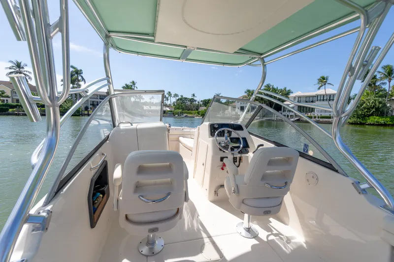 Slide: The Image of 2018 Grady-White Freedom 255 boat interior with dual seats, steering, and scenic waterfront view. - 27