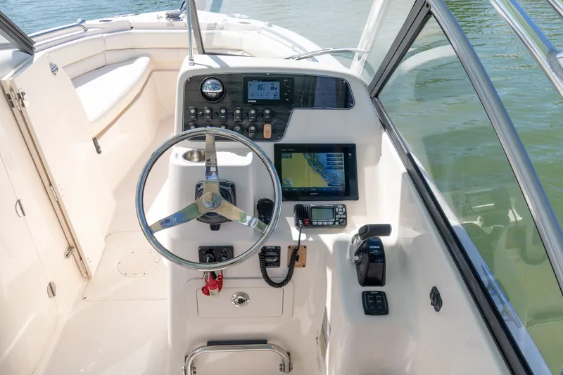 Slide: The Image of 2018 Grady-White Freedom 255 boat helm with steering wheel and navigation controls. - 29