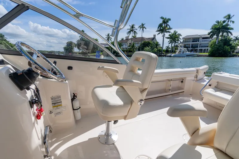 Slide: The Image of 2018 Grady-White Freedom 255 boat interior with helm, seats, and waterfront view. - 31