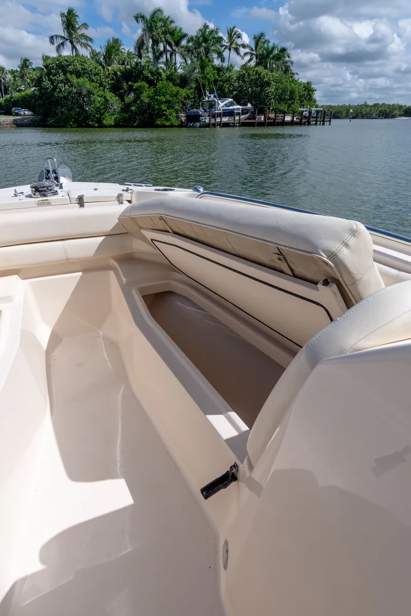 Slide: The Image of 2018 Grady-White Freedom 255 boat interior with seating, near tropical shoreline. - 33
