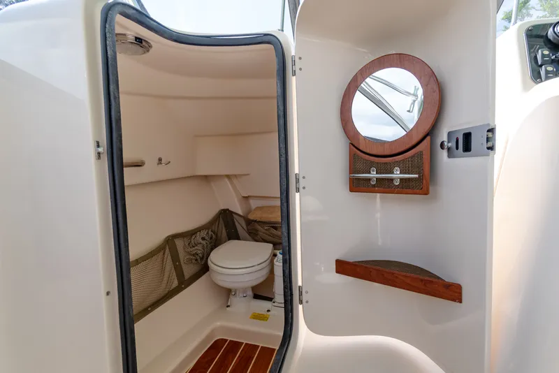 Slide: The Image of 2018 Grady-White Freedom 255 boat interior with compact bathroom and round mirror. - 39
