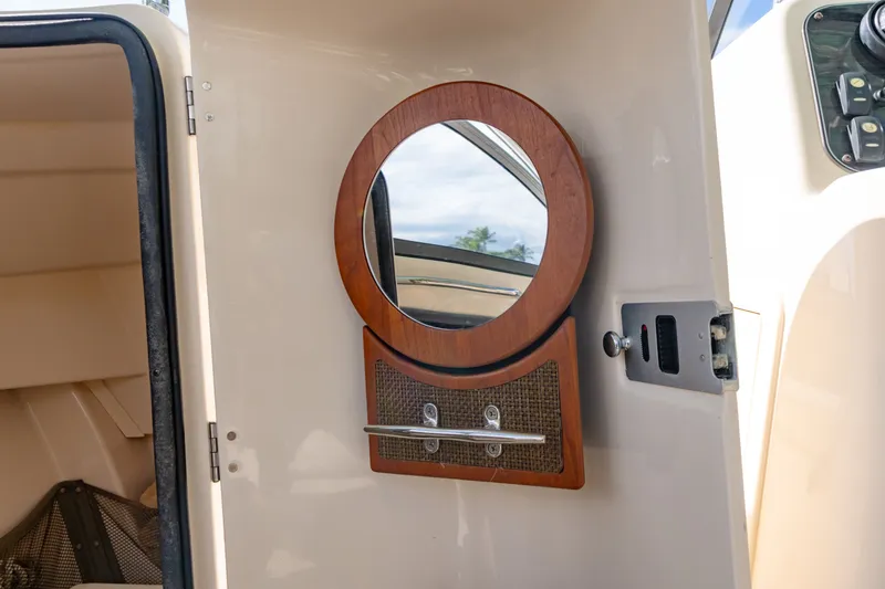 Slide: The Image of 2018 Grady-White Freedom 255 cabin interior with round mirror and storage compartment. - 40