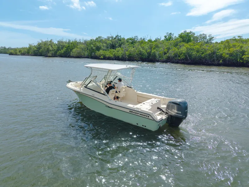 Slide: The Image of 2018 Grady-White Freedom 255 boat cruising on a sunny day near lush shoreline. - 8