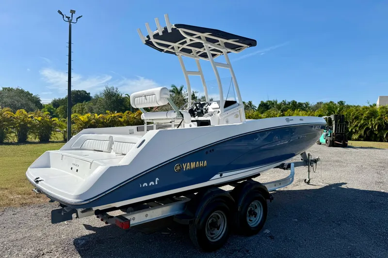 Slide: The Image of 2018 Yamaha Boats 210 FSH Sport on trailer, parked outdoors under clear blue sky. - 20