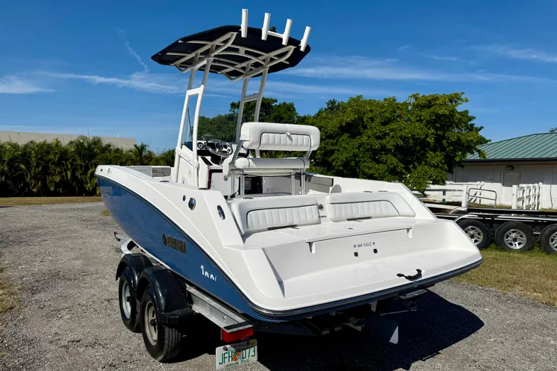 Slide: The Image of 2018 Yamaha Boats 210 FSH Sport on trailer, parked outdoors, showcasing sleek design. - 21