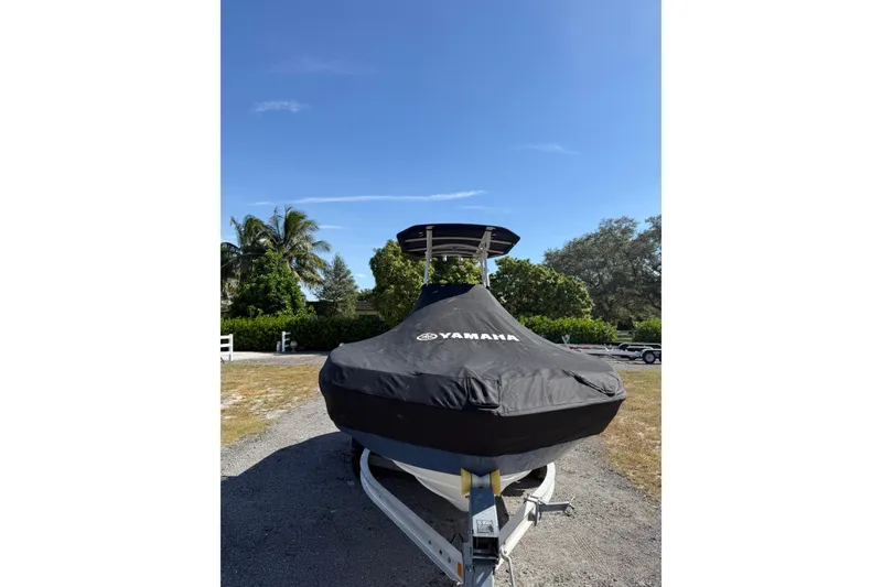 Slide: The Image of 2018 Yamaha Boats 210 FSH Sport covered, parked outdoors on a sunny day. - 22