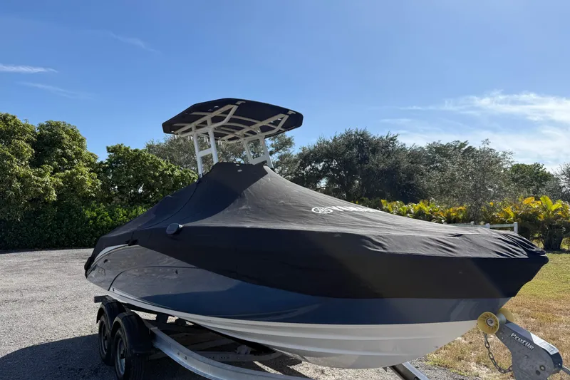 Slide: The Image of 2018 Yamaha Boats 210 FSH Sport covered, parked on trailer, sunny day. - 23