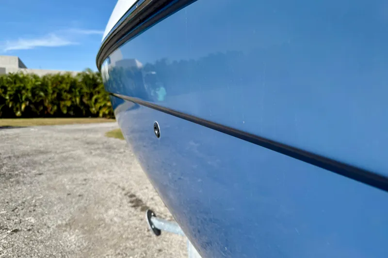 Slide: The Image of Close-up of a 2018 Yamaha Boats 210 FSH Sport hull, showcasing sleek blue design. - 3