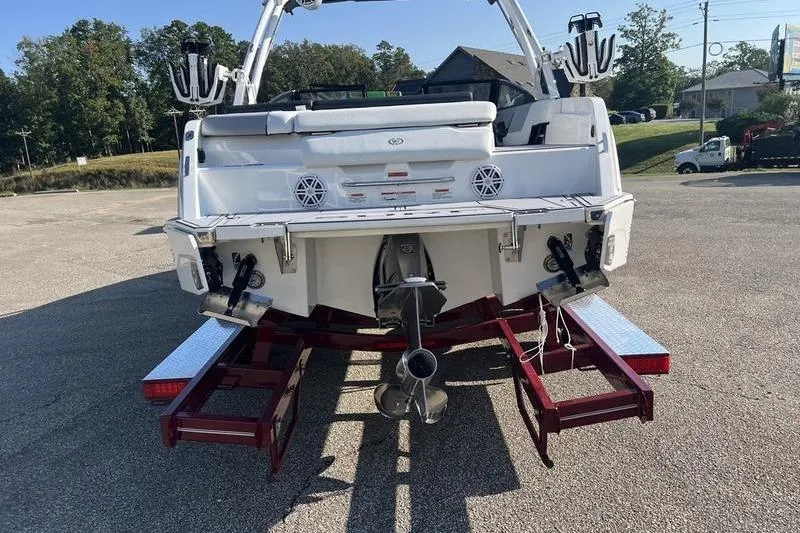 Slide: The Image of 2025 Cobalt CS23 Surf boat on trailer, rear view showing propeller and speakers. - 18