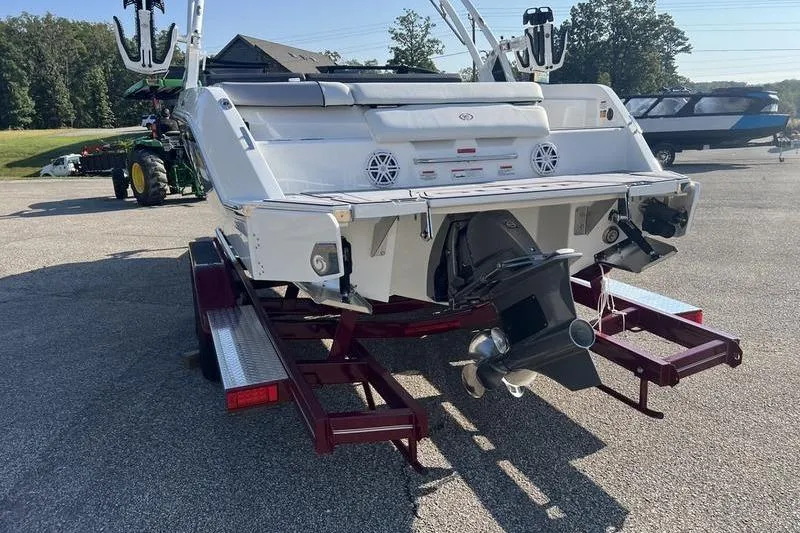 Slide: The Image of 2025 Cobalt CS23 Surf boat on trailer, rear view showing propeller and speakers. - 19