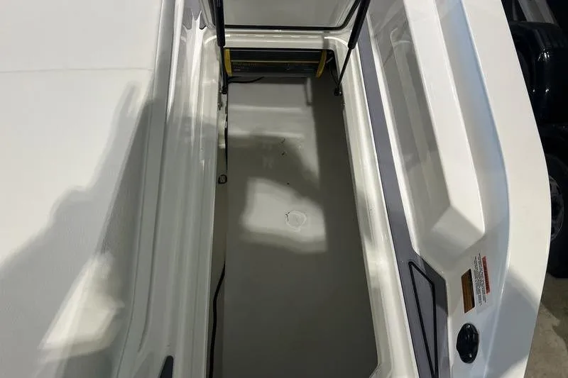 Slide: The Image of 2025 Cobalt CS23 Surf boat interior storage compartment, featuring sleek white design. - 25