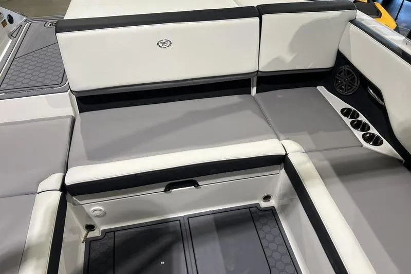 Slide: The Image of 2025 Cobalt CS23 Surf boat interior with gray and white seating, cup holders, and speaker. - 27