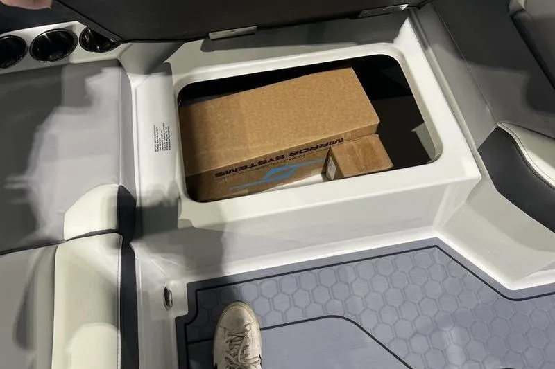 Slide: The Image of 2025 Cobalt CS23 Surf boat storage compartment with cardboard boxes inside. - 31