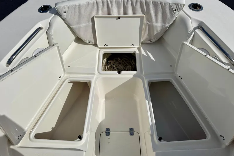 Slide: The Image of 2023 Key West 263 FS boat storage compartments with open hatches and visible rope. - 15