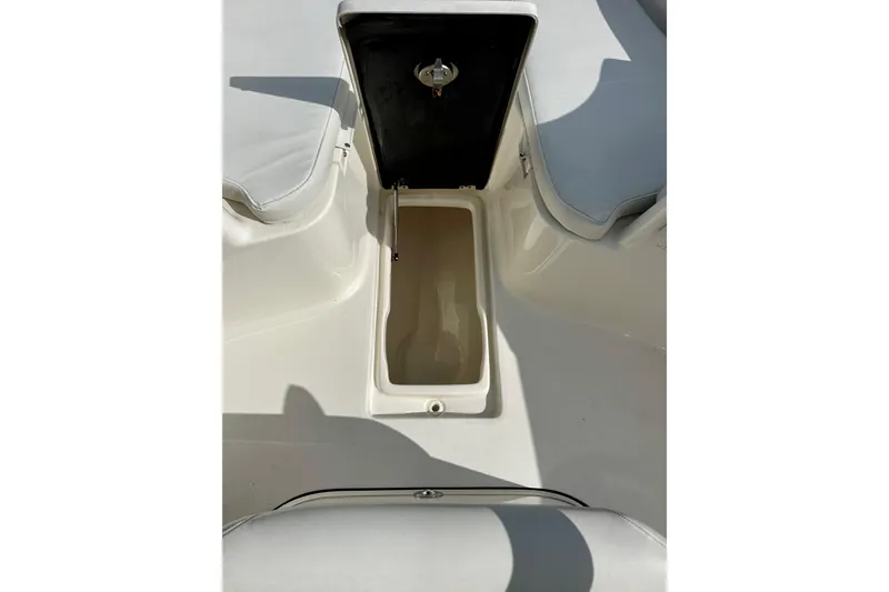 Slide: The Image of 2023 Key West 263 FS boat storage compartment with open lid, showcasing interior space. - 18