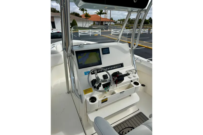 Slide: The Image of 2023 Key West 263 FS boat dashboard with navigation screen and steering wheel. - 26