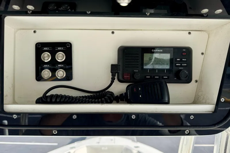 Slide: The Image of 2023 Key West 263 FS boat dashboard with Garmin radio and accessory switches. - 32
