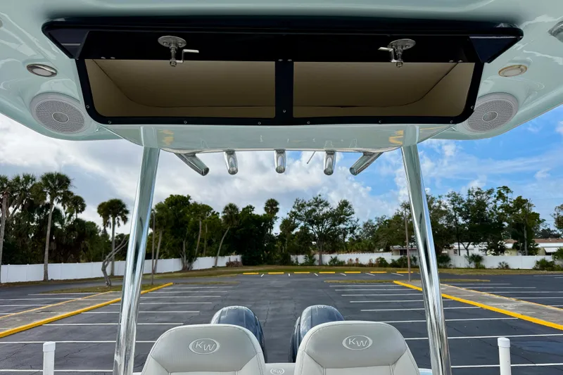 Slide: The Image of 2023 Key West 263 FS boat interior with rod holders and speakers, parked outdoors. - 46