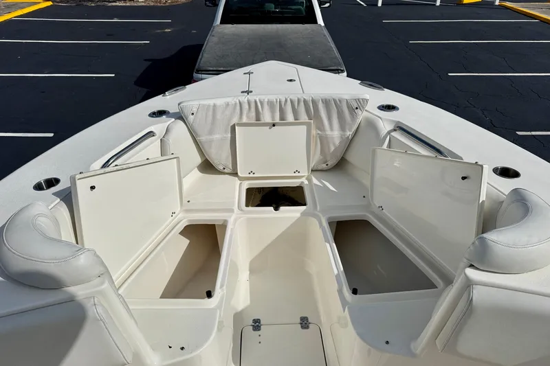 Slide: The Image of 2023 Key West 263 FS boat with open storage compartments in a parking lot. - 9