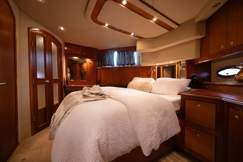 Slide: The Image of Luxurious 2005 Cruisers Yachts 455 Express Motoryacht bedroom with elegant wood finishes. - 15