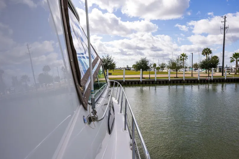 Slide: The Image of 2005 Cruisers Yachts 455 Express Motoryacht docked by a scenic waterfront. - 22