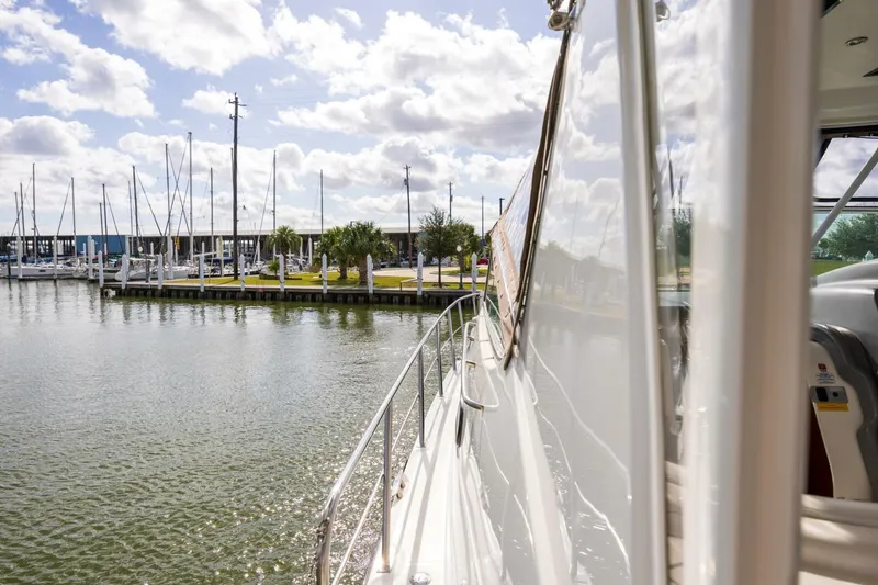 Slide: The Image of 2005 Cruisers Yachts 455 Express Motoryacht docked at a marina under a cloudy sky. - 23