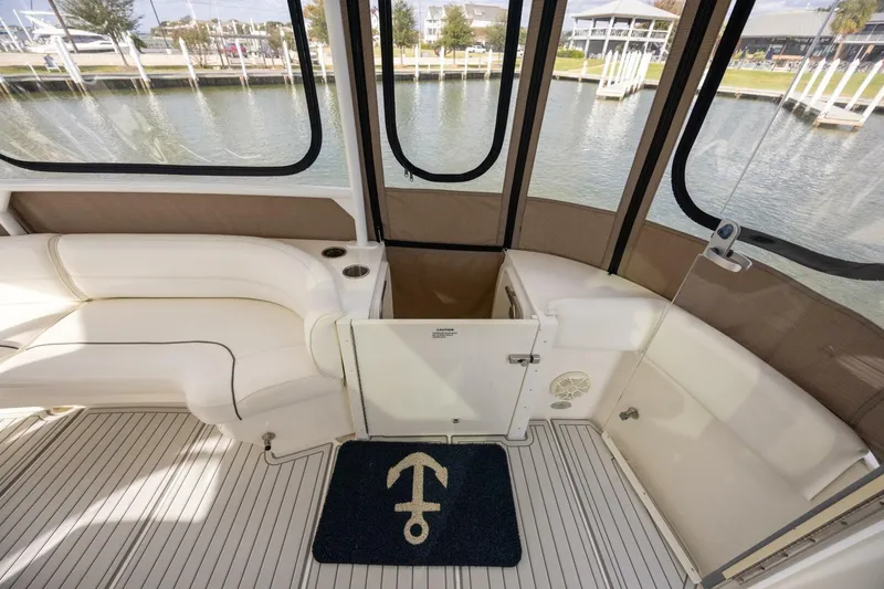 Slide: The Image of 2005 Cruisers Yachts 455 Express Motoryacht interior with white seating and anchor-themed mat. - 25