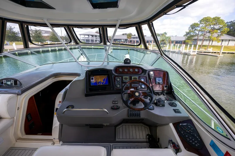 Slide: The Image of 2005 Cruisers Yachts 455 Express Motoryacht helm with modern navigation equipment and waterfront view. - 30