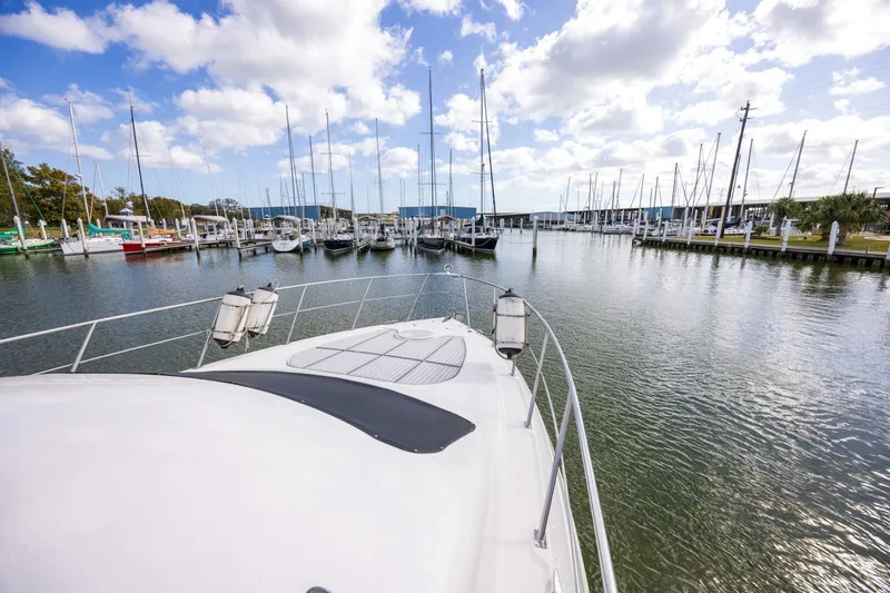 Slide: The Image of 2005 Cruisers Yachts 455 Express Motoryacht docked in a marina under a partly cloudy sky. - 36