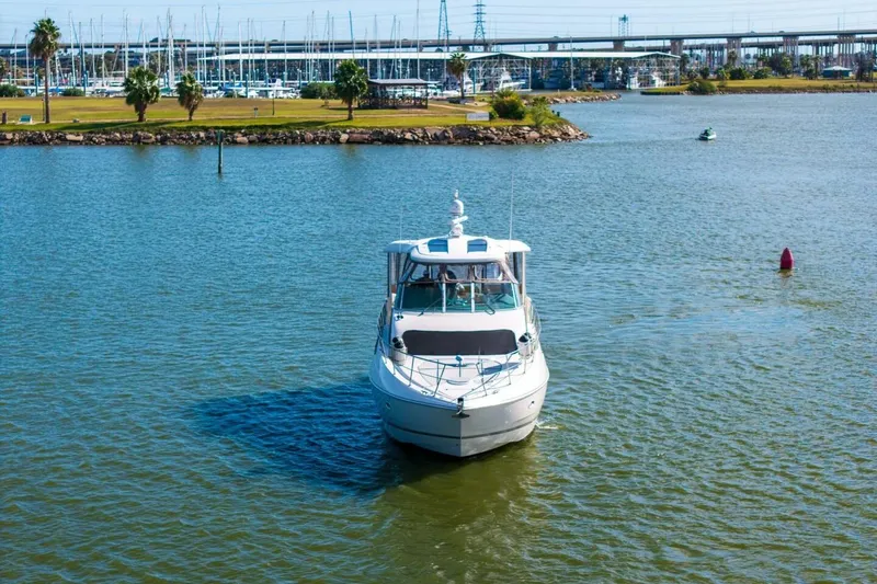 Slide: The Image of 2005 Cruisers Yachts 455 Express Motoryacht on calm water near marina. - 38