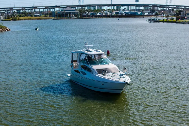 Slide: The Image of 2005 Cruisers Yachts 455 Express Motoryacht on calm water near a bridge. - 39