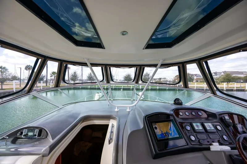 Slide: The Image of 2005 Cruisers Yachts 455 Express Motoryacht helm with panoramic windows and navigation controls. - 5