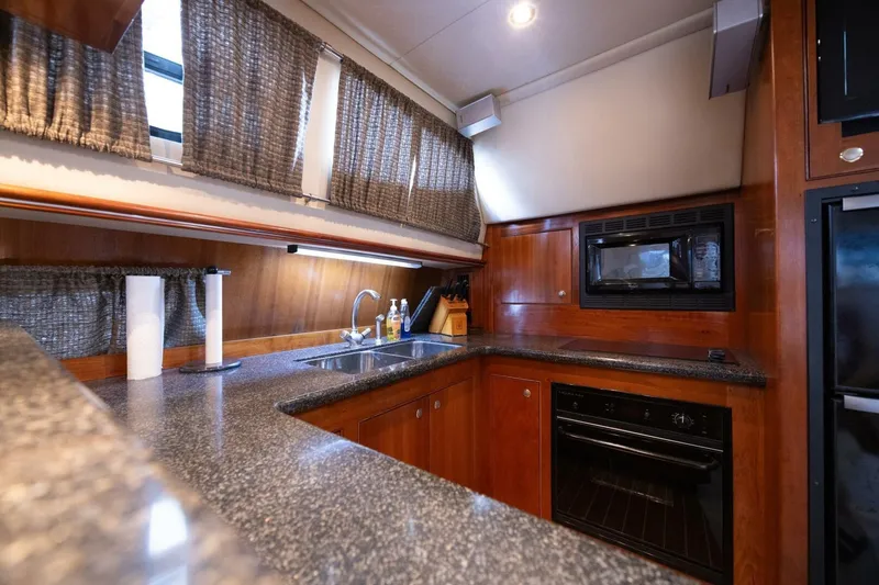 Slide: The Image of 2005 Cruisers Yachts 455 Express Motoryacht kitchen with granite countertops and modern appliances. - 7