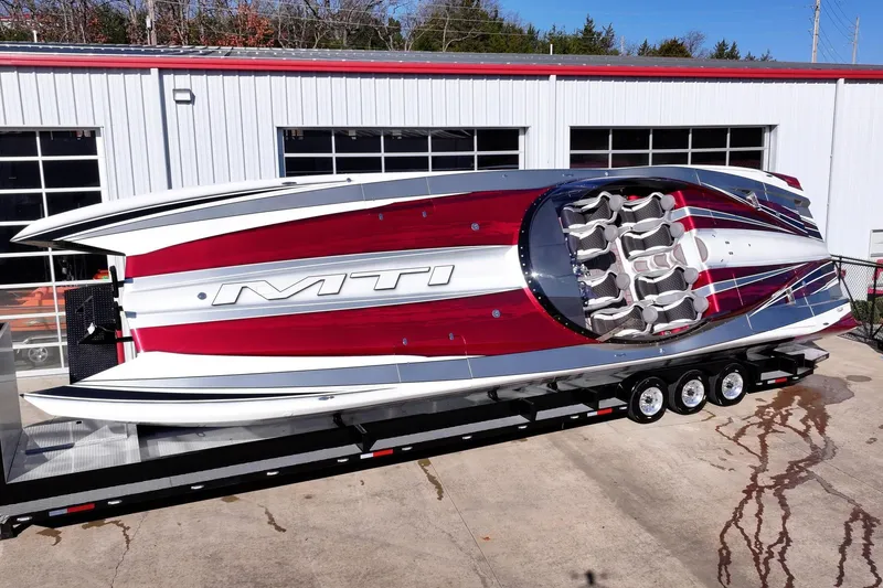 The Image of 2016 MTI 48 powerboat on trailer, sleek design with red and white accents. - 0