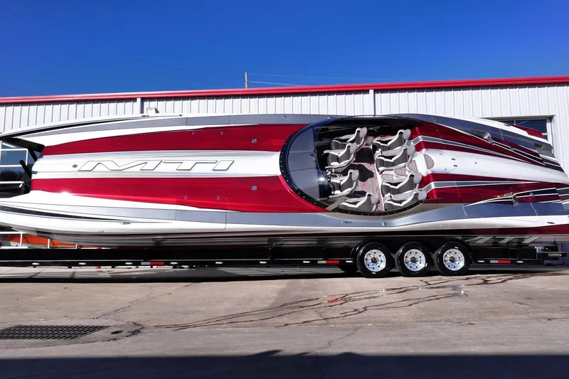 Slide: The Image of 2016 MTI 48 powerboat with sleek red and white design on a trailer. - 11