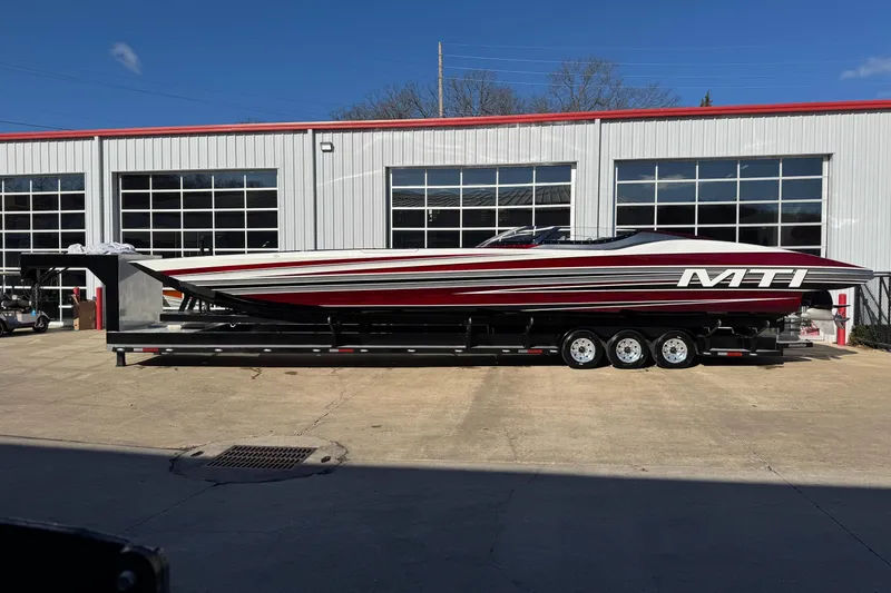 Slide: The Image of 2016 MTI 48 boat on trailer outside a garage with large windows. - 14