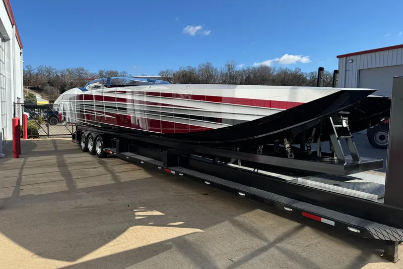 Slide: The Image of 2016 MTI 48 powerboat on trailer, red and white design, parked outdoors. - 16