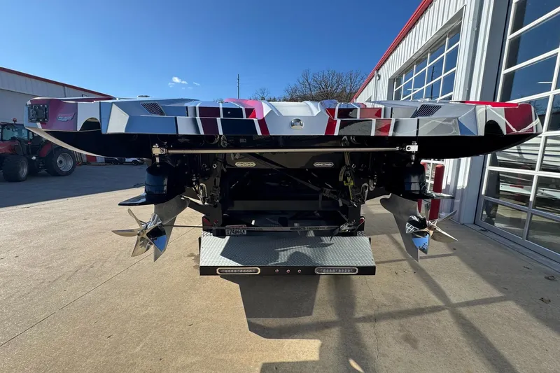 Slide: The Image of Rear view of a 2016 MTI 48 boat with dual propellers, parked outside a garage. - 18