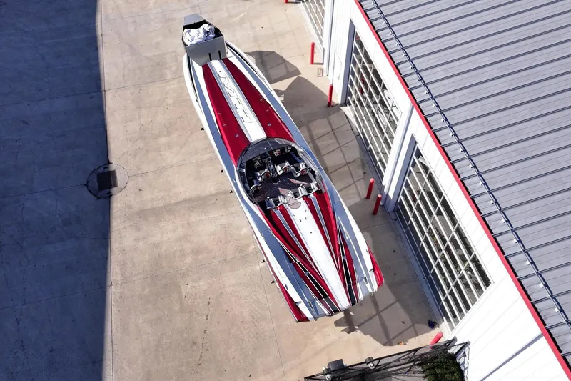 Slide: The Image of Aerial view of a 2016 MTI 48 speedboat with red and white stripes near a building. - 3