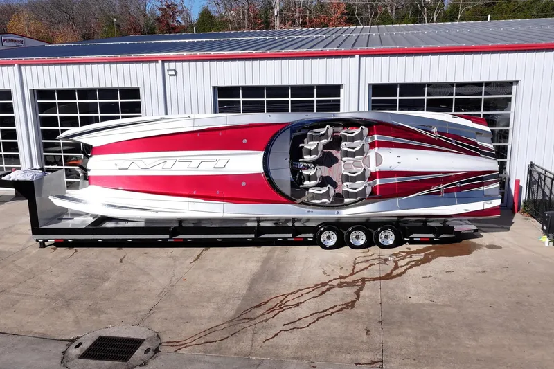 Slide: The Image of High-performance 2016 MTI 48 speedboat on trailer, featuring sleek red and white design. - 5