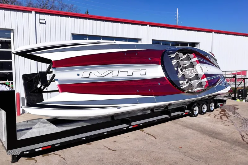 Slide: The Image of 2016 MTI 48 powerboat on trailer, featuring sleek red and white design. - 6