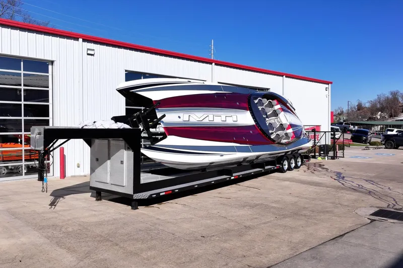 Slide: The Image of 2016 MTI 48 boat on trailer outside a white building under clear blue sky. - 7