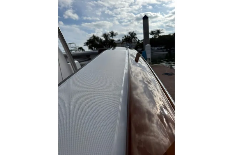 Slide: The Image of 2026 Mag Bay 43 CC luxury boat interior with cushioned seating, on calm water at sunset. - 22