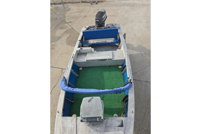 Slide: The Image of 1976 Custom Aluminum 16 boat with green carpet and blue seating, featuring an outboard motor. - 6