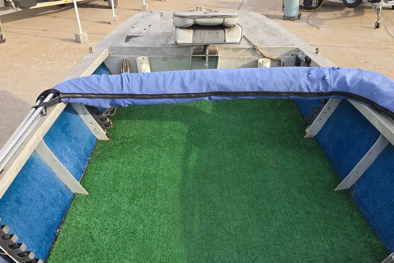 Slide: The Image of 1976 Custom Aluminum 16 boat interior with green and blue carpeting, docked outdoors. - 10