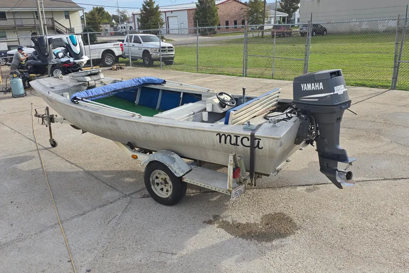 Slide: The Image of Custom 1976 Aluminum 16 boat with Yamaha motor on trailer in a parking lot. - 5