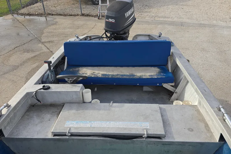 Slide: The Image of 1976 Custom Aluminum 16 boat interior with blue seating and Yamaha outboard motor. - 7