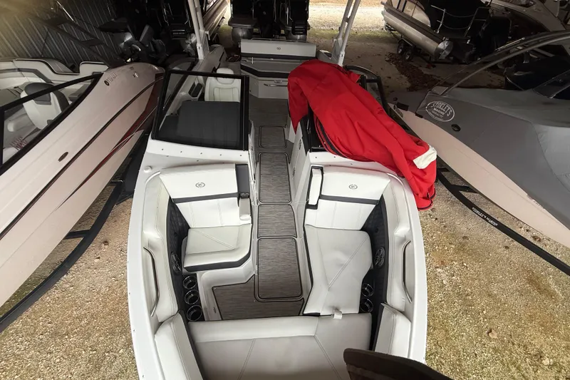 Slide: The Image of 2025 Cobalt R6 boat interior with white seating and red cover in storage. - 12