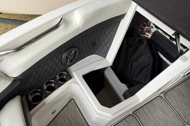 Slide: The Image of 2025 Cobalt R6 boat interior storage compartment with cup holders and speaker. - 14